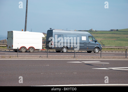 Blue van il traino di un rimorchio su M62. Foto Stock