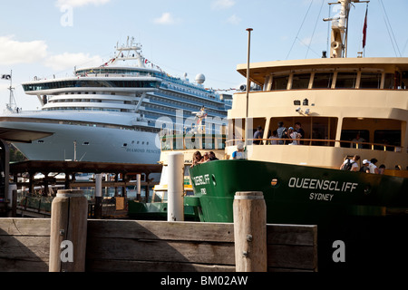 La gente sul traghetto Manly accanto a una nave da crociera in Circular Quay, Porto di Sydney Foto Stock