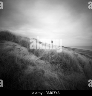 Figura unica su banchi di sabbia a Seashore Spurn Head Point Lighthouse, East Yorkshire, Inghilterra Foto Stock