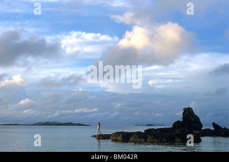 Donna in piedi sulle rocce, Castaway Island Resort Castaway Island, gruppo di isole di Mamanuca, Isole Figi Foto Stock