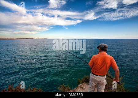 Pescatore sulla cima di una scogliera, città di portici, comune di Lagoa, distretto di Faro, regione di Algarve, PORTOGALLO Foto Stock