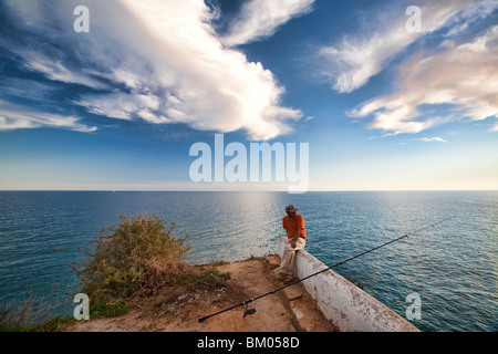 Pescatore sulla cima di una scogliera, città di portici, comune di Lagoa, distretto di Faro, regione di Algarve, PORTOGALLO Foto Stock