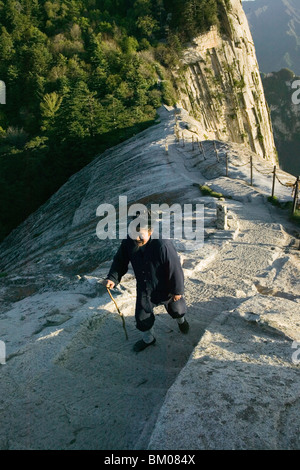 Monaco daoista sul pesce torna Ridge, avvicinando cui Yun Gong Monastero il picco del Sud, cammino di pellegrino lungo la scalinata in pietra con mano a catena Foto Stock