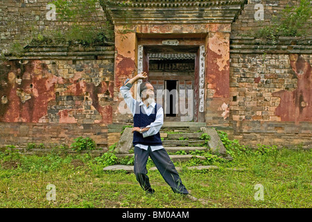 Master dimostra di Taichi movimenti, nella parte anteriore della sua vecchia casa al di sotto del picco, Wudang Shan, taoista di montagna, provincia di Hubei, Wu Foto Stock