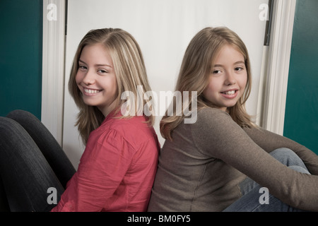 Blonde sorelle seduti insieme Foto Stock