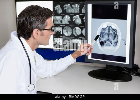 Medico di esaminare il report di MRI Foto Stock