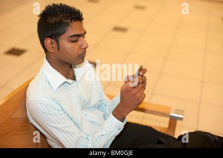 L'uomo la riproduzione su telefono cellulare in mall, KwaZulu Natal Provincia, Sud Africa Foto Stock