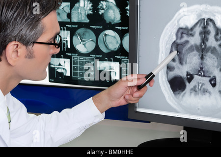 Medico di esaminare il report di MRI Foto Stock