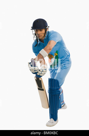 Cricket battitore la riproduzione in avanti corsa difensiva Foto Stock