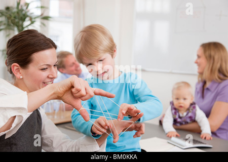 Imprenditrice, ragazzo giocando il gioco di stringa Foto Stock