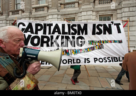 Un anti-capitalista demo con un banner di grandi dimensioni nel centro di Londra Foto Stock