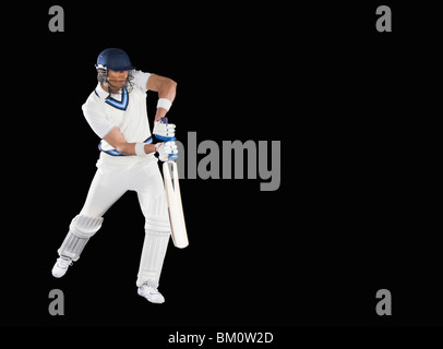 Cricket battitore la riproduzione in avanti corsa difensiva Foto Stock