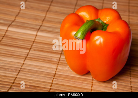 Peperone rosso isolato su una stuoia di bambù sfondo Foto Stock