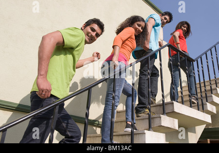 Gli amici lo spostamento su una scala Foto Stock