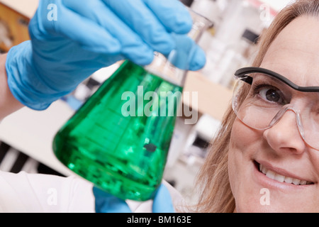 Medico donna tenendo una beuta in un laboratorio Foto Stock