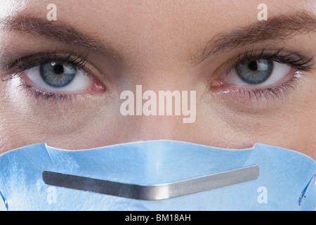 Medico donna che indossa una maschera di influenza Foto Stock