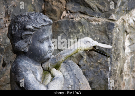 Cherubino tenendo un cigno con acqua versando da cigni bocca. Questa statua è sul display in corrispondenza di Bodnant gardens in Galles Foto Stock