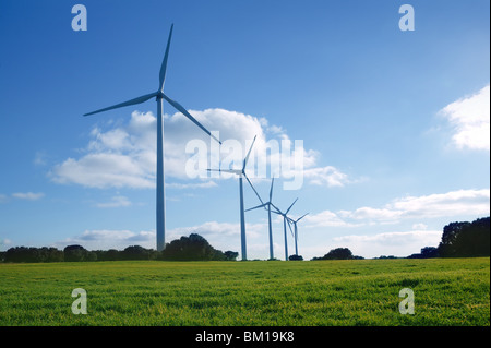 Ecologico di produzione di energia elettrica dai mulini a vento in un prato e cielo blu Foto Stock