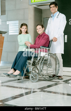 Medico spingendo una donna su una sedia a rotelle Foto Stock