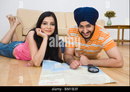 La religione sikh matura la lettura di una mappa e sorridente Foto Stock