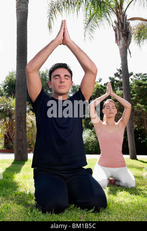 Matura la pratica dello yoga in un parco Foto Stock