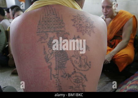 Un uomo si mette in mostra il suo tatuaggio durante il Wai Kru giorno al Wat Phra Bang, un tempio buddista in Thailandia dove i monaci devoti del tatuaggio. Foto Stock