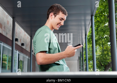 Infermiere della messaggistica di testo su un telefono cellulare Foto Stock