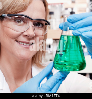 Medico donna tenendo una beuta in un laboratorio Foto Stock