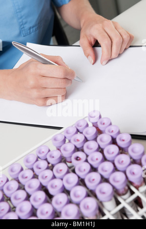 Femmina tecnico di laboratorio di preparazione di una relazione medica Foto Stock