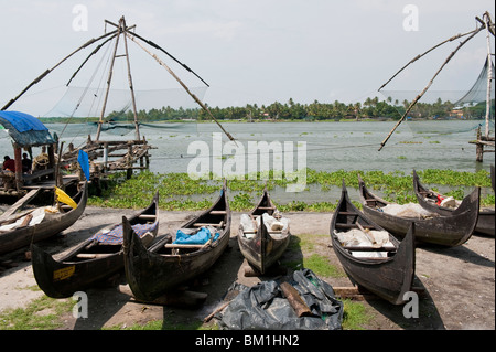 Spiaggiata canoe di pesca vicino al cinese di reti da pesca a Cochin, India Foto Stock