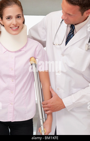 Medico aiutare un paziente a camminare Foto Stock