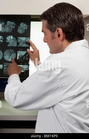 Medico di esaminare il report di MRI Foto Stock