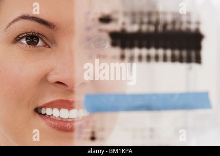 Donna scienziato esaminando una relazione in un laboratorio Foto Stock
