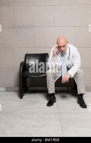 Medico seduto su una sedia e la ricerca ha sottolineato Foto Stock