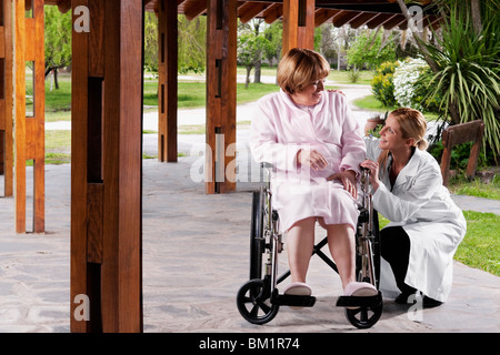 Medico seduto vicino a un paziente e sorridente Foto Stock