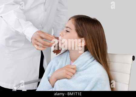 Metà vista in sezione di un medico dando la medicina di una ragazza Foto Stock