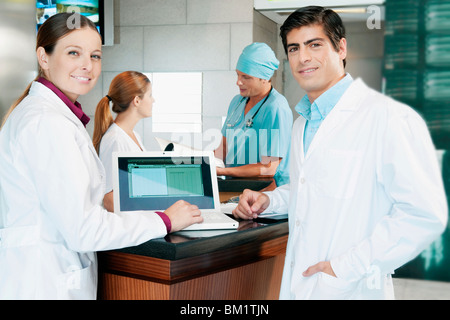 Due medici a discutere di una relazione medica su un computer portatile Foto Stock