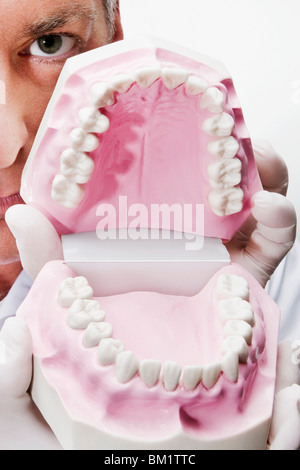 Dentista tenendo una serie di protesi Foto Stock