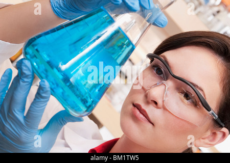 Medico donna tenendo una beuta in un laboratorio Foto Stock