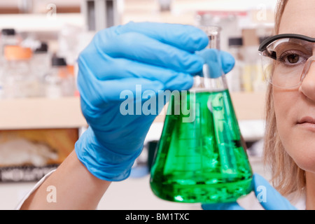 Medico donna tenendo una beuta in un laboratorio Foto Stock