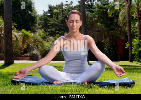 La donna a praticare yoga in un parco Foto Stock
