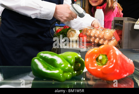 Addetto alle vendite la scansione di prezzo delle uova con un lettore di codice a barre Foto Stock