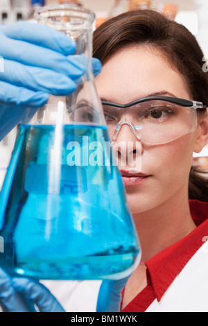 Medico donna tenendo una beuta in un laboratorio Foto Stock