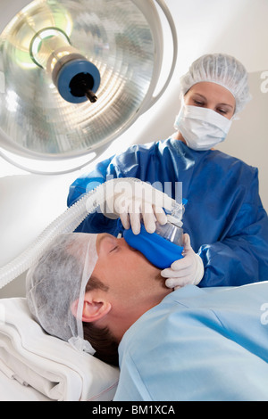 Medico anestetizzante un paziente in sala operatoria Foto Stock