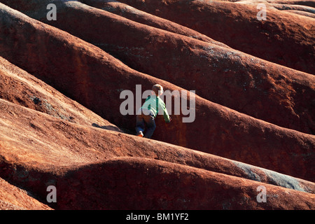 Little Boy a giocare tra la massa esposta in badlands Foto Stock