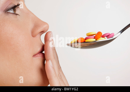 Close-up di una donna con un cucchiaio di pillole Foto Stock