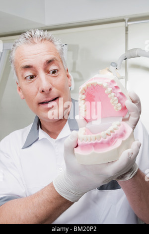 Dentista tenendo una serie di protesi Foto Stock
