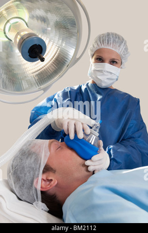 Medico anestetizzante un paziente in sala operatoria Foto Stock