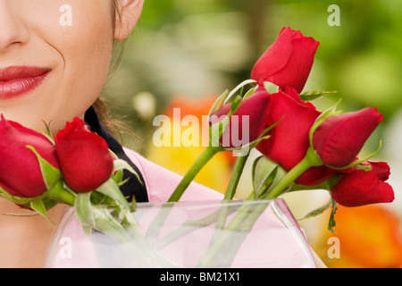 Donna profumati fiori in una serra Foto Stock