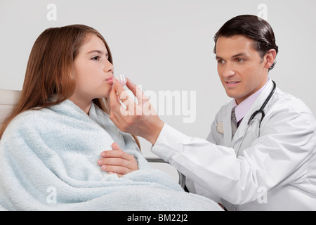 Medico dando la medicina di una ragazza Foto Stock